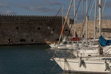 Heraklion, Girit Yunanistan Mart 12021: Girit 'teki eski Venedik limanı Heraklion' da tekneler. Venedik kalesinin manzarası, Koule..
