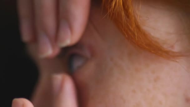 接触レンズに指と点滅を置く茶色の目の若い女性のクローズアップ ビジョン改善のためのコンタクトレンズの広告 光学店 健康管理と医学の概念 — ストック動画