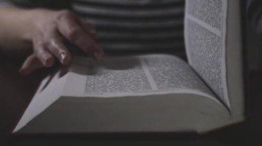 Hands gliding on the sheets of the red book I open and read the Bible 4k Cinematic Slow motion