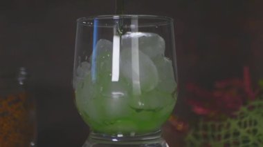 Yavaşça yeşil içeceği bir bardak buzun içine boşalt Yavaş Sinema