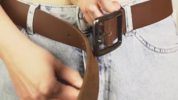 女人的手把蛇拴在她们的牛仔裤上 然后用细腰勒紧棕色的腰带 4K水平视频 视频摄像 — 图库视频影像