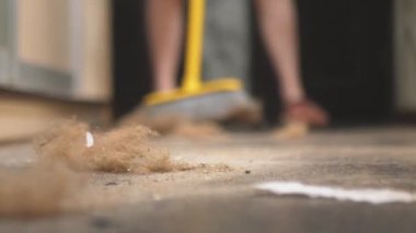 Evi paspasla süpüren bir kızın yakın çekimi. Kameranın lensine çok fazla toz girdi. 4K çözünürlüğü. Yatay video