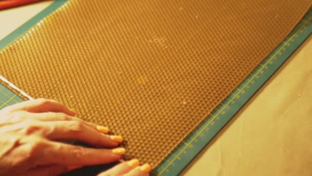 여자는 허니콤을 뒤틀고 소재에서 양초를 만듭니다 여자는 바느질에 종사하고 있습니다 — 비디오