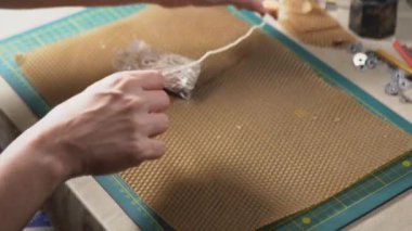 Kadınların elleri, gelecekteki mum 4K videosu için fitilin uzunluğunu ölçer. Estetik