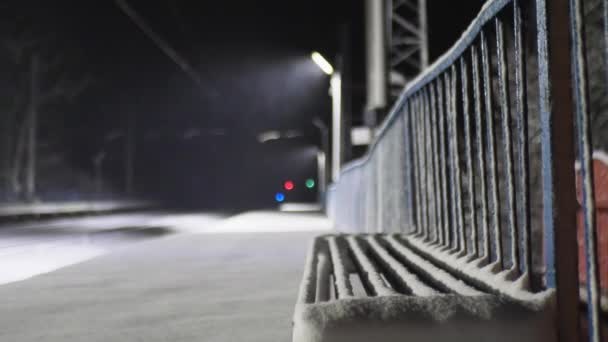 鉄道の雪で覆われたベンチのクローズアップ ナイト ビデオ — ストック動画
