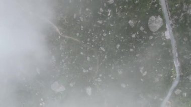Kayalarla kaplı ve sisle kaplanmış engebeli bir dağ arazisinin havadan görünüşü. Doğa görselleri için ideal.