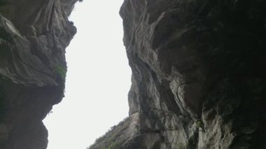 Bulutlu bir gökyüzüne uzanan kayalık bir kanyonun hayranlık uyandırıcı görüntüsü, görkemini gözler önüne seriyor..