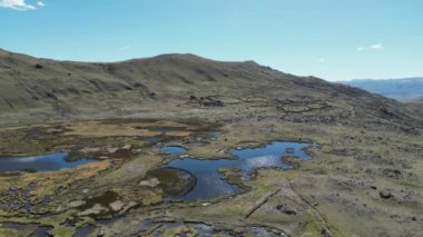 Açık gökyüzünün altındaki dağlık arazide bataklık ve su manzarası güzel doğa manzarası sergiliyor.