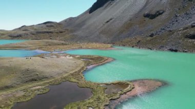 Engebeli dağ arazisine kurulmuş turkuaz göllerin güzel hava görüntüleri. Bir doğa aşığı rüyasında görür..