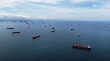 Hava görüntüsü, tekne ve gemilerle dolu yoğun bir su kütlesini gösteriyor. Deniz manzarasındaki hareketlilik ve hareketliliği vurguluyor.