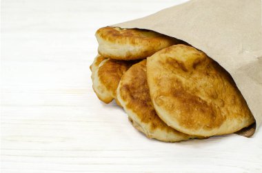 Beyaz ahşap arka planda kağıt ekolojik torbalar içinde hamur işleri.