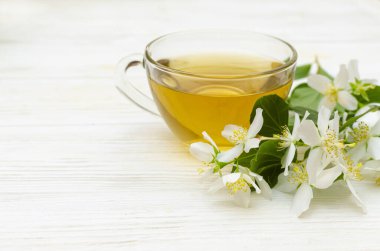 Beyaz arka planda bir fincan yasemin çayı, beyaz yasemin çiçekleri. Uzayı kopyala Çay Saati.