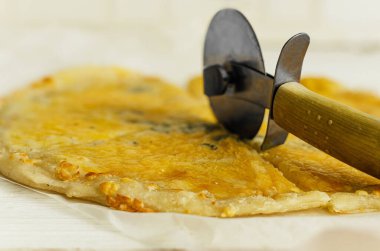 Yakın plan. Pizzacıyla taze pişmiş pizza kes..