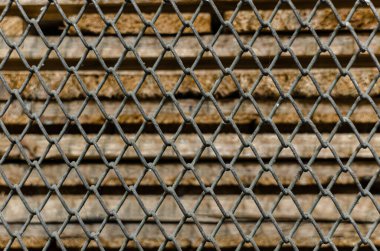 Eski paslı tel örgüler ve arka planda eski ahşap çarşaflar.