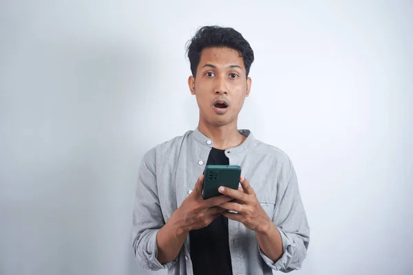Junger Asiatischer Mann Mit Überraschtem Gesichtsausdruck Hält Smartphone Der Hand — Stockfoto