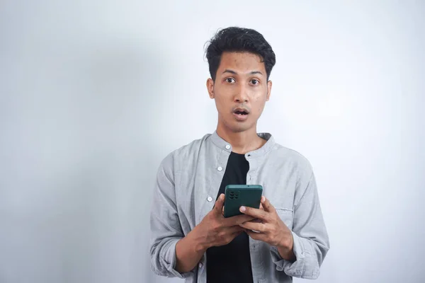 Giovane Asiatico Con Espressione Facciale Sorpresa Tenere Smartphone Mano Digitando — Foto Stock