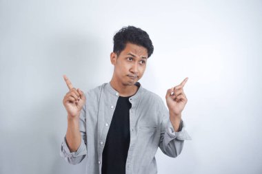 İzole edilmiş arka planda duran yakışıklı genç adam farklı yönleri gösteren kendine güvenle gülümsüyor. reklam için kopyalama alanı