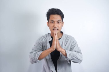 Gömlekli bir adam kollarını göğsünün önünde kavuşturdu. Ya da inananların duası