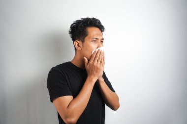 Genç adamın alerjisi var. Öksürük ve hapşırık alerjisi var. Toza alerjisi var. Nazofarnx 'ı tahriş ediyor..