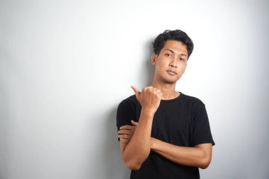 Tecrit edilmiş genç yakışıklı bir adam bir ürün sunmak için kenarı işaret ediyor.