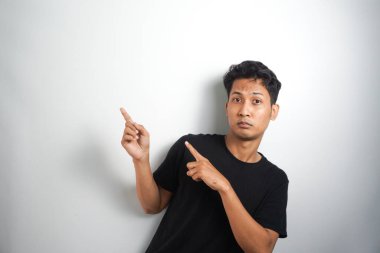 Tecrit edilmiş genç yakışıklı bir adam bir ürün sunmak için kenarı işaret ediyor.