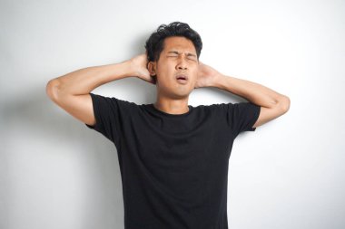 Beyaz arka planda elleri başının üstünde duran bir adam portresi..