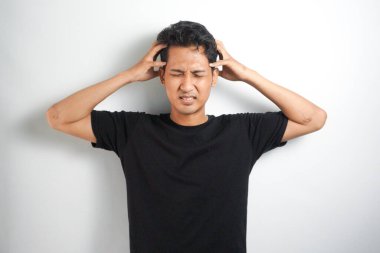 Beyaz arka planda elleri başının üstünde duran bir adam portresi..