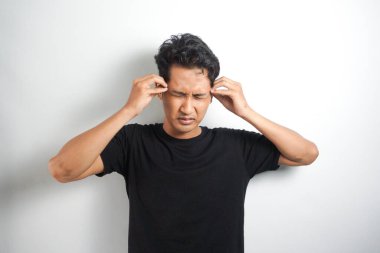 Beyaz arka planda elleri başının üstünde duran bir adam portresi..