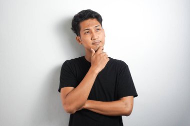 Beyaz arka plan duvarında izole edilmiş düşünceli bir adamın fotoğrafı. Kenara bak..