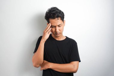 Beyaz arka planda elleri başının üstünde duran bir adam portresi..