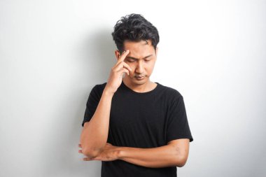 Beyaz arka plan duvarında izole edilmiş düşünceli bir adamın fotoğrafı. Kenara bak..