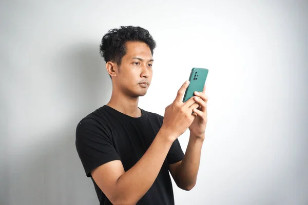 Asian Man Seriously Concentrated Smartphone Isolated White Background — Stockfoto