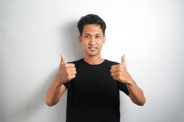 Mutlu bir gencin portresi başparmak kaldırıyor.