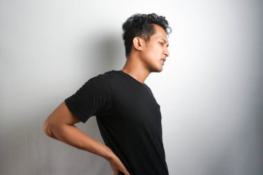 Sırt ağrısı çeken bir adam. Sırt ağrısı. Adam acı içinde sırtını tutuyor. Tıbbi konsept.