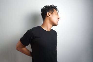 Sırt ağrısı çeken bir adam. Sırt ağrısı. Adam acı içinde sırtını tutuyor. Tıbbi konsept.