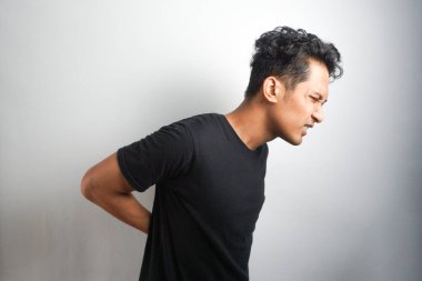 Sırt ağrısı çeken bir adam. Sırt ağrısı. Adam acı içinde sırtını tutuyor. Tıbbi konsept.