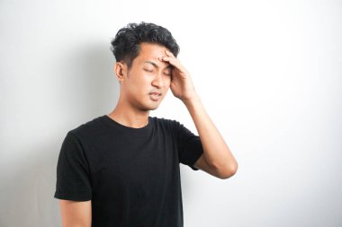 Beyaz arka planda elleri başının üstünde duran bir adam portresi..