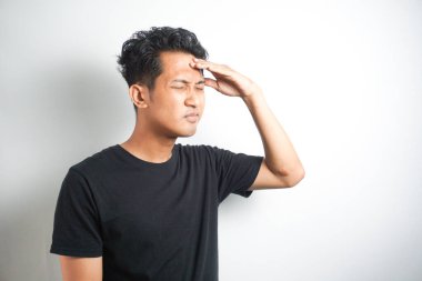 Beyaz arka planda elleri başının üstünde duran bir adam portresi..