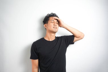 Beyaz arka planda elleri başının üstünde duran bir adam portresi..