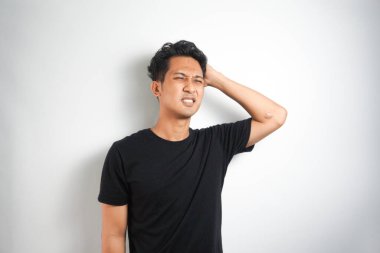 Beyaz arka planda elleri başının üstünde duran bir adam portresi..