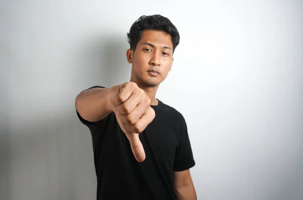 Młody Przystojny Azji Mężczyzna Pokazując Kciuk Dół Wyrażając Niechęć — Zdjęcie stockowe
