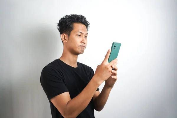 Asian Man Seriously Concentrated Smartphone Isolated White Background — Stockfoto