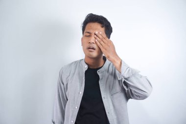 Güçlü göz ağrısı çeken Asyalı genç bir adam. Gözünü tutan erkek bir acı hissetti. Migrenim tuttu.