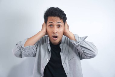 İki kulağını da beyaz arka planda tutan genç bir adamın portresi. Yüksek sesten acı çekiyor..