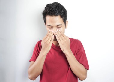 Sad and depressed man holding his head with his hands. a man holds his nose and sinus area with his fingers with obvious pain due to headache in front forehead area
