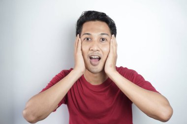 Emotionally frightened black haired man, seen with a frightened expression upon seeing something horrific ahead, looks nervously at the camera, showing phobia. Human reactions and emotions