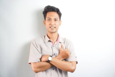 Handsome Asian young man with arms crossed over chest looking at camera