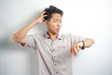 Shocked asian man in casual looking at watch