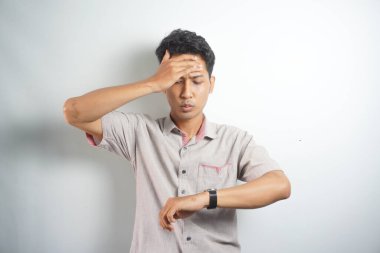 Shocked asian man in casual looking at watch