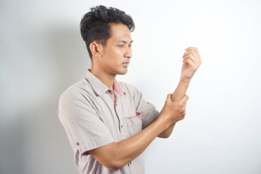 Hand pain, Handsome asian young man wearing shirt is having arm pain